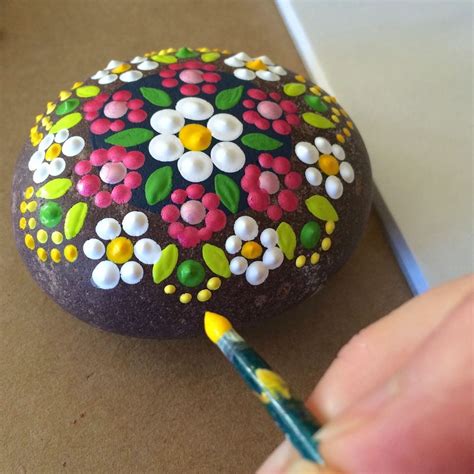 Decorating rocks with paint brush strokes. Use a paint brush and dot with different colors to ...