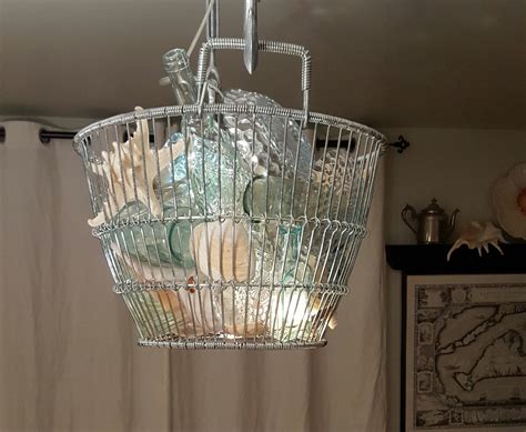 The color palette of the beach is revealed in this coastal chandelier made from a clamming ...