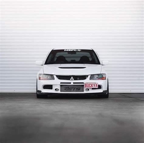 a white car parked in front of a garage door