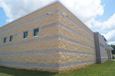 a building that has some grass in front of it and blue sky behind the building