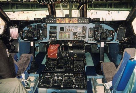 two pilots in the cockpit of an airplane looking at their instruments and control panels