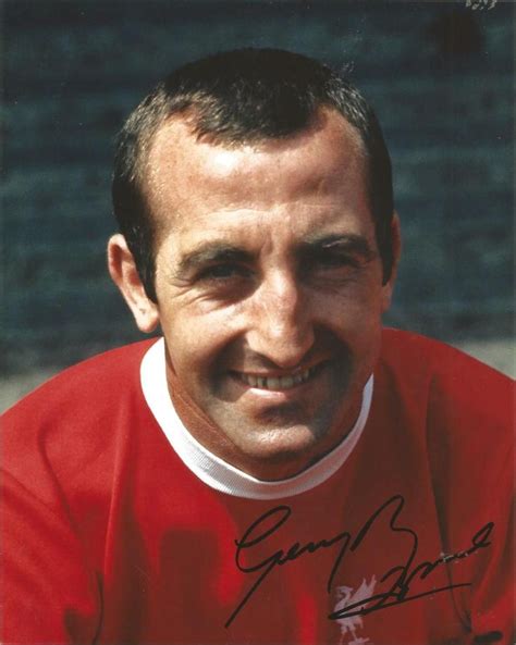 a man in an orange shirt smiles at the camera