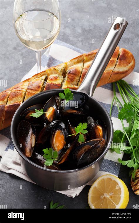 Mussels in copper pot and white wine on stone table Stock Photo - Alamy