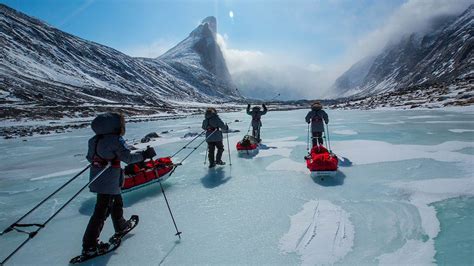 several people on skis are standing in the snow near some mountains and ...