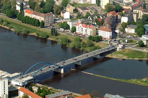 an aerial view of a bridge spanning the width of a river with buildings on both sides