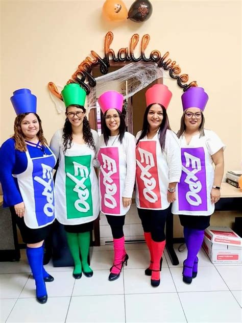 four women in funny hats and bodysuits are posing for a photo with each other