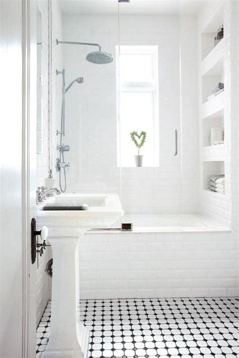 a white bathroom with black and white floor tiles