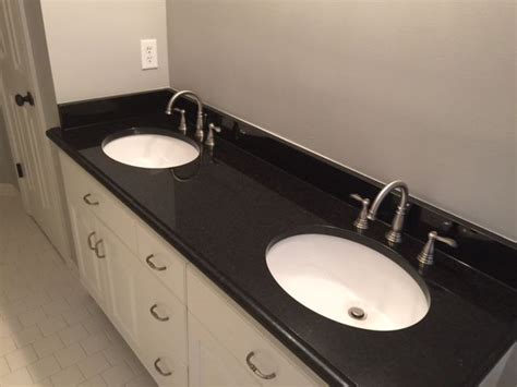 two white sinks sitting on top of a black counter