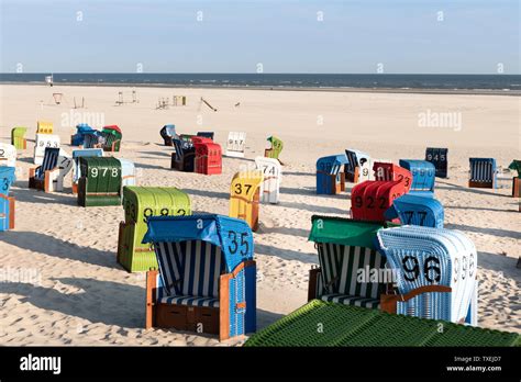 Colorful beach chairs in white sand in the morning on the Frisian ...