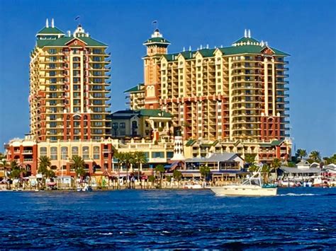 a large building sitting on top of a body of water next to a boat in front of it