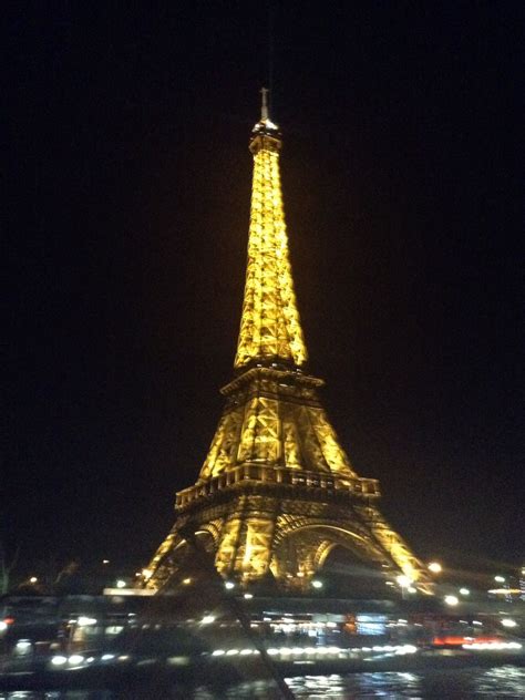 The Eiffel Tower all lit up at night during the Seine River cruise ...