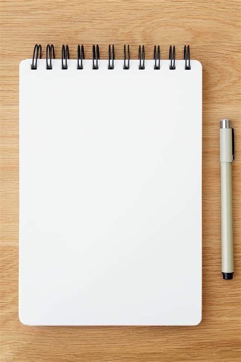 Blank plain white notebook page with a pen