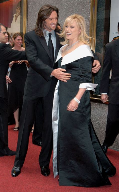 a man and woman standing next to each other in front of a red carpeted ...