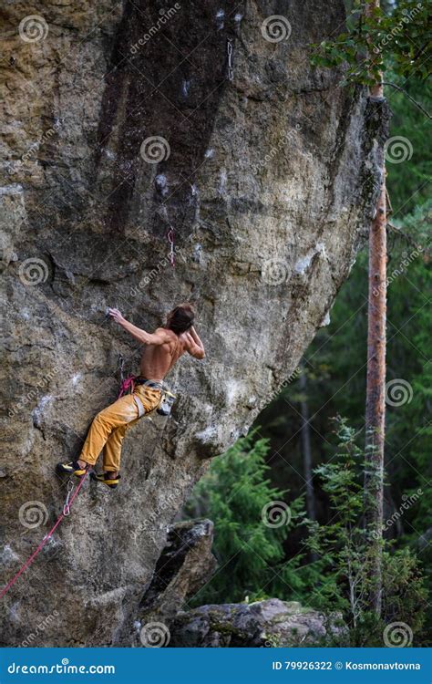 Young Athletic Male Rock Climber Climbing Cliff Wall. Copy Space on the Right Stock Photo ...