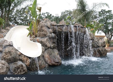 A Waterfall In To A Pool In A Luxury Backyard With Tropical Landscaping ...