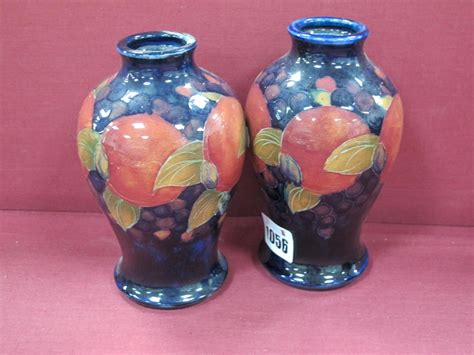 A Pair of Moorcroft Pottery Vases, of ovoid form, painted in the 'Pomegranate' pattern against dark