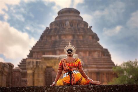 Odissi dancer pose in front of sun temple with sculptures in Konark ...