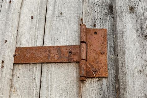 Premium Photo | Rusty metal door hinge. door hinge on a wooden wall.