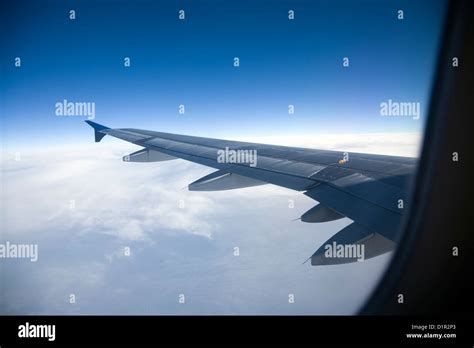 Airplane wing and clouds seen from cabin window Stock Photo - Alamy