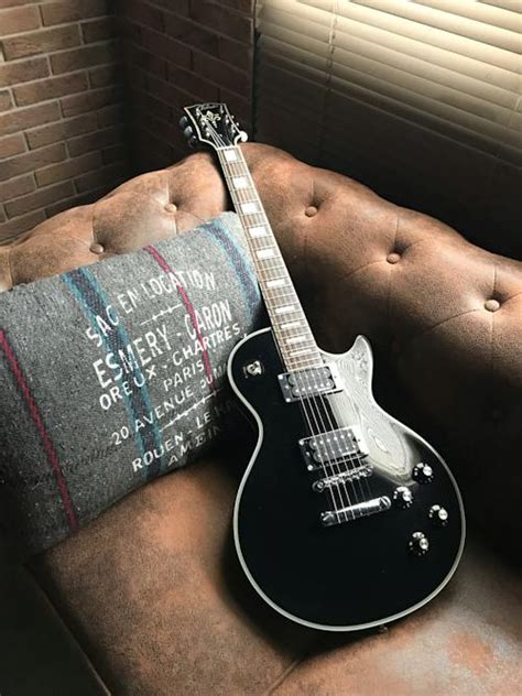 Brown Acoustic Guitar Leaning on Brown Velvet Couch · Free Stock Photo