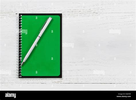 Green spiral notepad with pen on desktop Stock Photo - Alamy