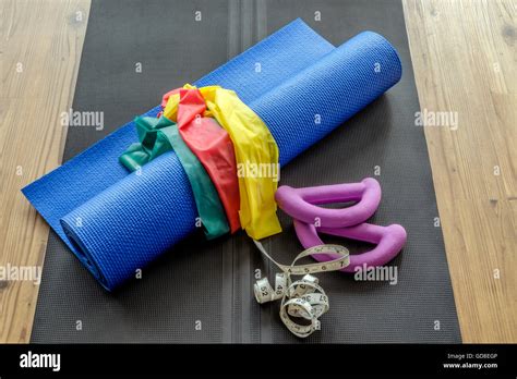 Selection of colorful home gym equipment on yoga mat against wooden floor background Stock Photo ...