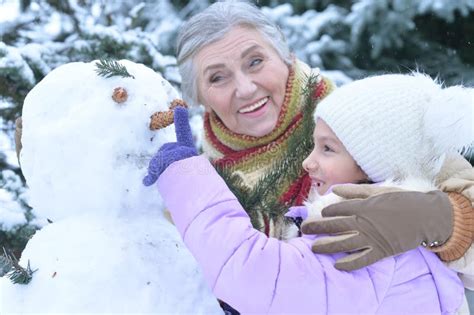 Portrait of Grandmother and Granddaughter Making Snowman in Winter Stock Photo - Image of ...