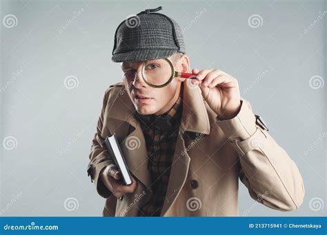 Male Detective Looking through Magnifying Glass on Grey Background ...