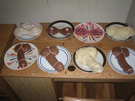 a wooden table topped with plates filled with cakes and desserts covered in icing