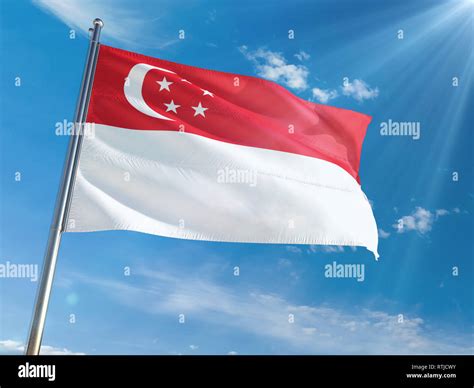 Singapore National Flag Waving on pole against sunny blue sky ...