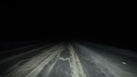 Car Driving On Winter Night Road While Strong Snow Flying Towards In ...