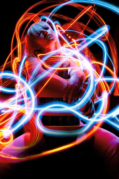 a woman sitting in front of a laptop computer covered in light painting circles on the screen