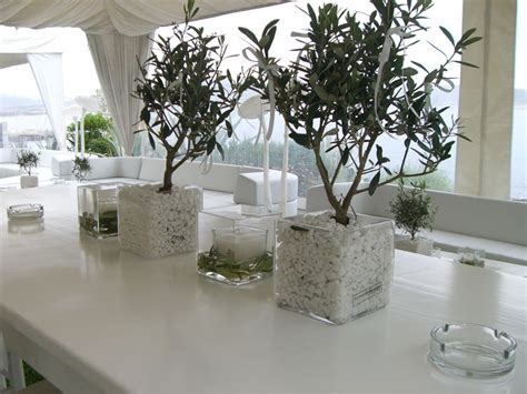 there are three small trees in vases on the dining room table with ...