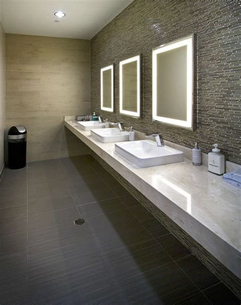 a bathroom with two sinks and three mirrors