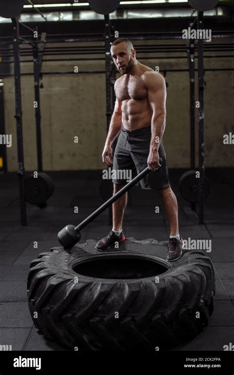 good looking atlete doing sledgehammer exercise. sledhammer workout Stock Photo - Alamy