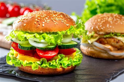 Delicious fresh homemade burger with lettuce, cheese, onion and tomato on a white wooden ...