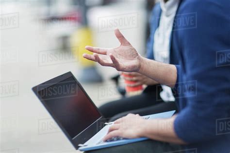 Business people with laptop talking outdoors - Stock Photo - Dissolve