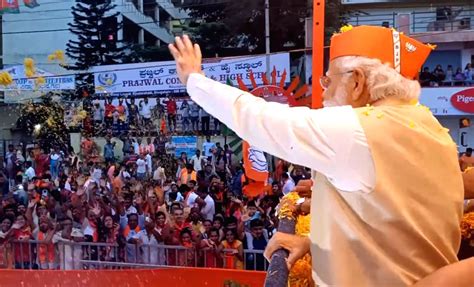 Prime Minister Narendra Modi waves at crowd during a roadshow