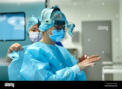 Surgeons wear sterile clothing before surgery. A team of surgeons preparing for surgery, set up ...