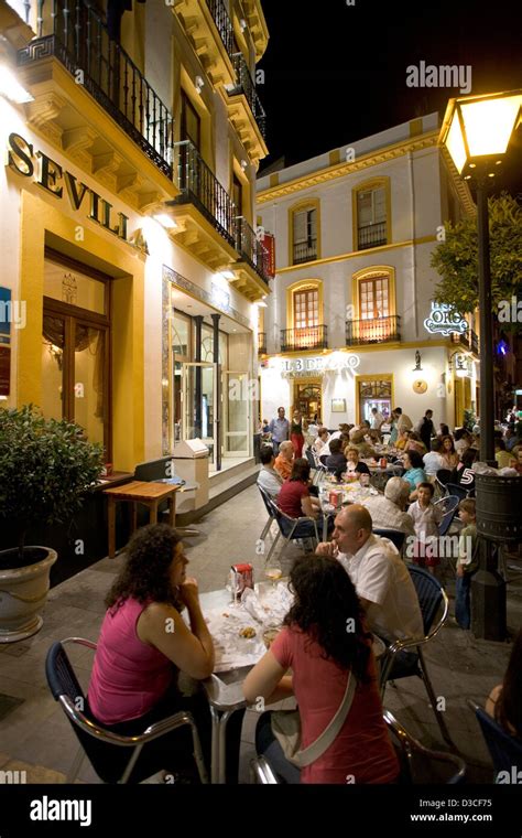 diners at an outdoor cafe at night outside a hotel in Seville Spain ...