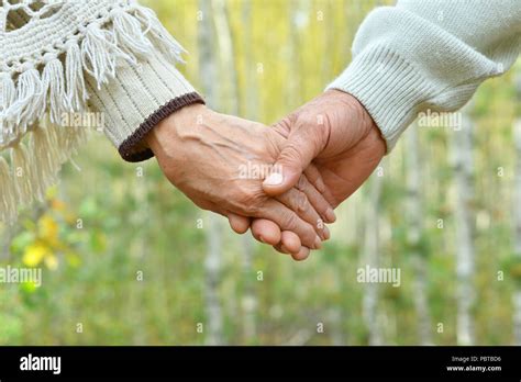 Elderly couple holding hands Stock Photo - Alamy