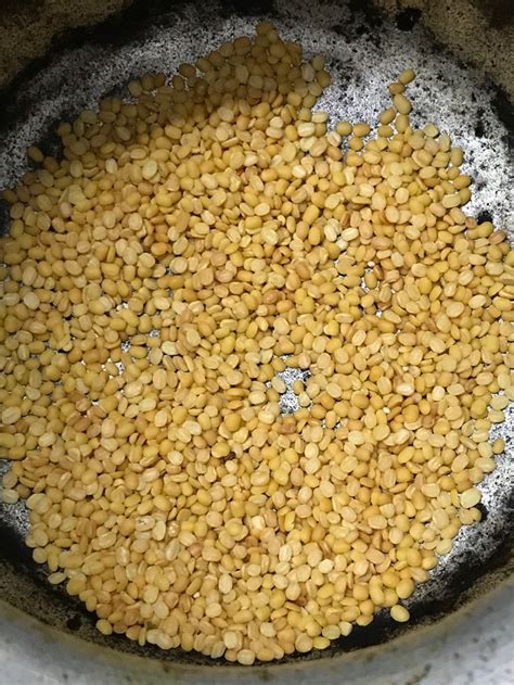 a pan filled with yellow lentils on top of a stove burner next to a ...