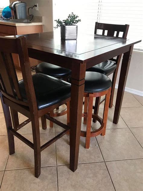 Small high top kitchen table. 2 chairs and 2 stools. Has some puppy bites o. The bottom of the ...