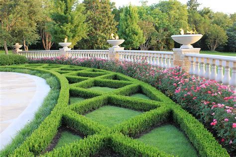 Classic boxwood hedges framed by cast stone ballustrade and fire bowls. Harold Leidner Landscape ...