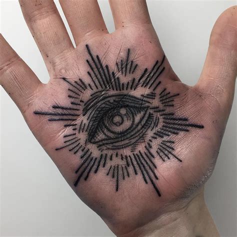 a hand with an all seeing eye tattoo on it