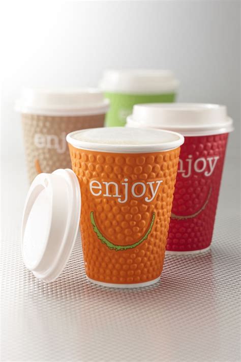 three coffee cups with lids sitting next to each other
