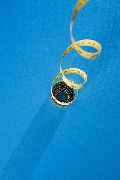 Premium Photo | Curve tape measure on blue background
