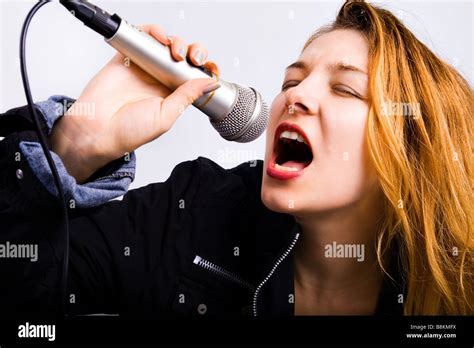 Young female karaoke singer singing music at microphone Stock Photo - Alamy