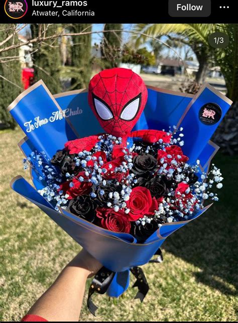 someone is holding a bouquet of flowers in the shape of a spider man with red, white and blue roses