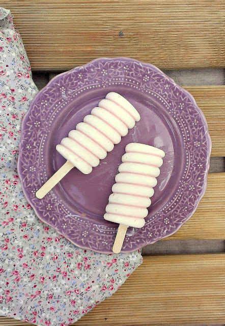 two popsicles on a purple plate sitting on top of a wooden table next to a napkin